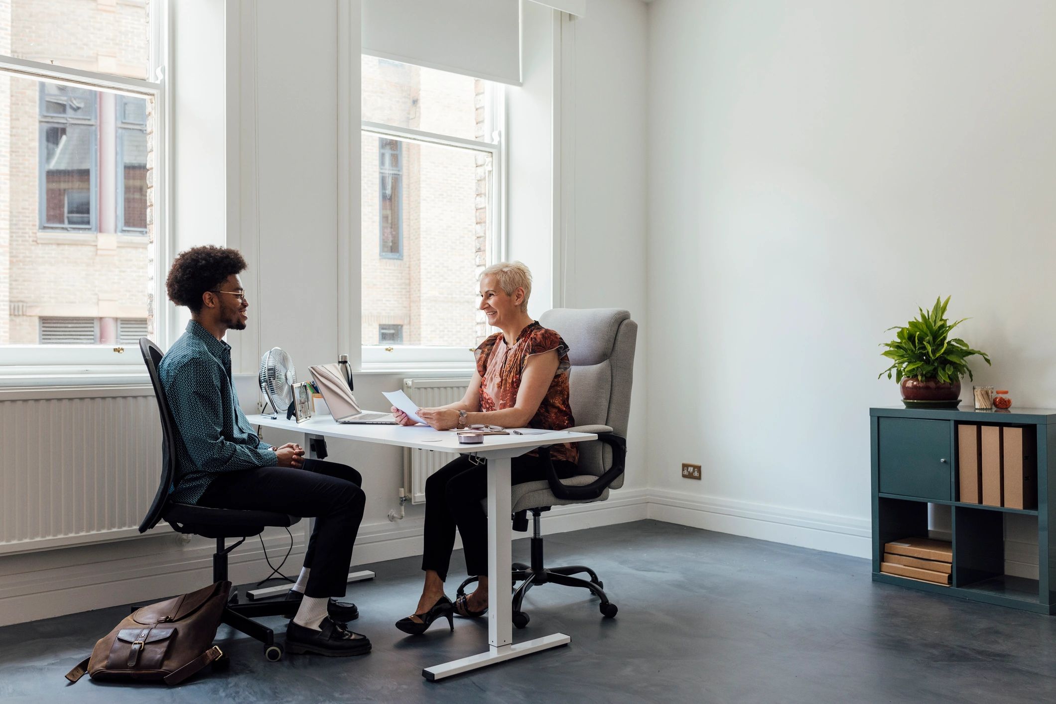 Professional business conversation across a desk