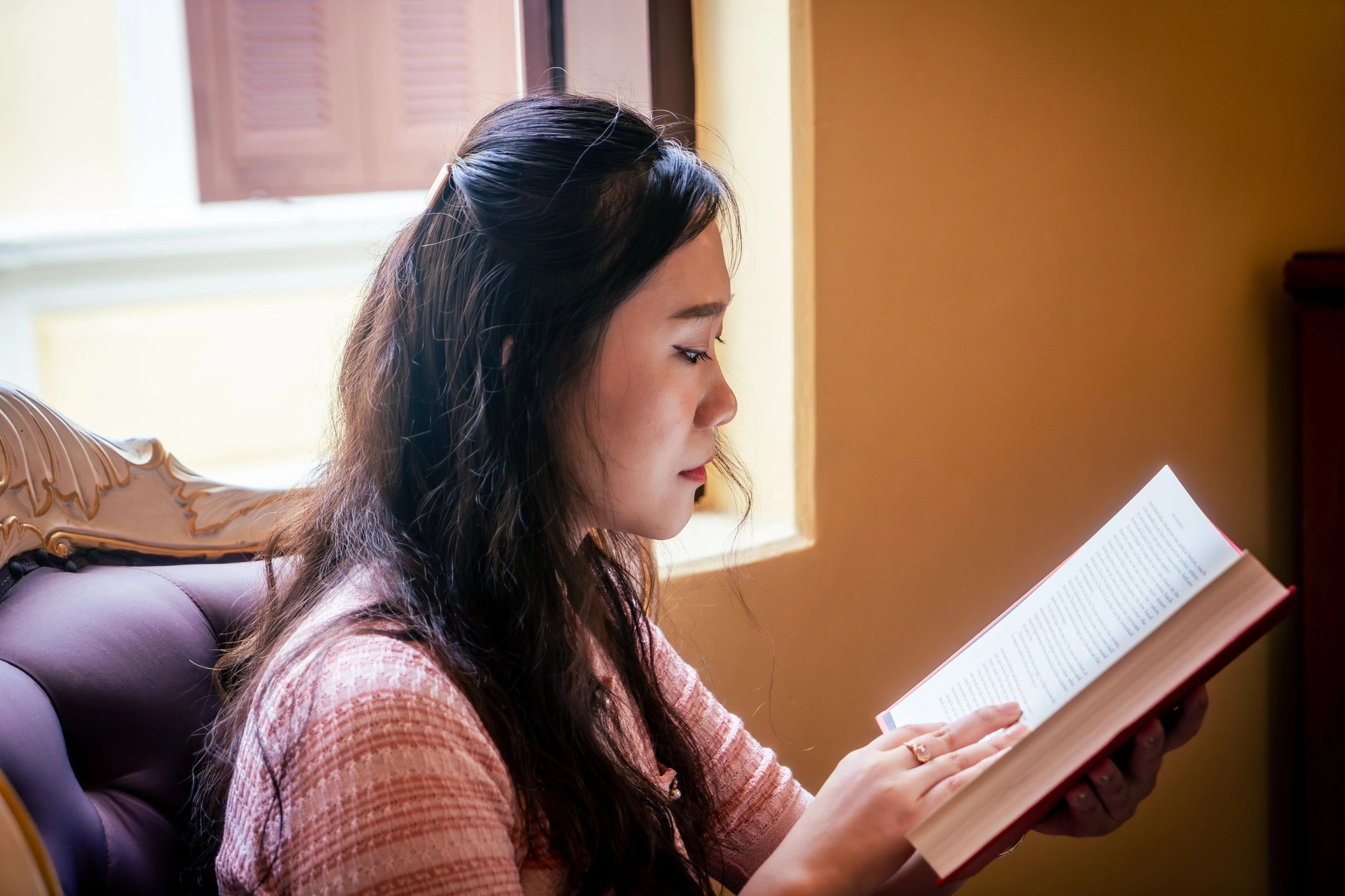 Woman reading a book in a hotel room